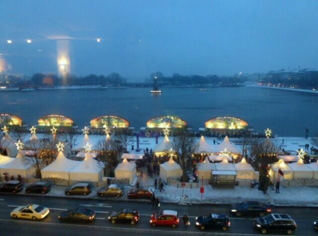 Blick aus dem Café-Restaurant vom Alsterhaus - über die Zelte des Weihnachtsmarktes am Jungfernstieg - über die Alster-Märchen-Schiffe - auf den beleuchteten Weihnachtsbaum in der Mitte der Binnenalster