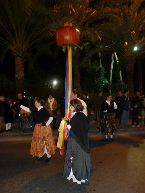 Frauen tragen einen Granatapfel.