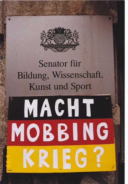 Plakat "MACHT MOBBING KRIEG?" zum 1. Mai 1999 am Dienstgebäude des Senators für Bildung, Wissenschaft, Kunst und Sport in Bremen
