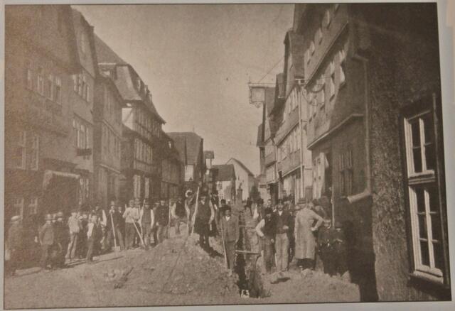 Kalenderblatt APRIL - Verlegung der Wasserleitung in der Borngasse. Auf der linken Seite ist die Gaststätte "Hessischer Hof" und rechts das Gasthaus "Zur Sonne" zu erkennen.