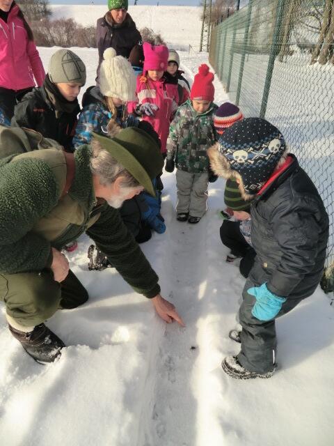 Jäger Helmut erklärt den Kindern die Tierspuren
