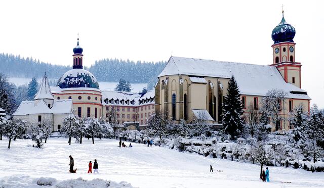 Wanderer und Rodler am Kloster