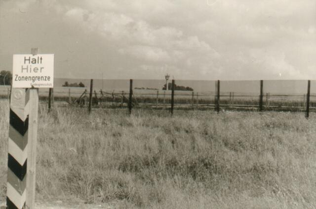 Die deutsch-deutsche Grenze. In der Bundesrepublik wurde sie als Zonengrenze bezeichnet. Die vordere Hinweistafel steht auf dem Gebiet der BRD, der schwarz-rot-goldene Grenzpfahl auf dem Gebiet der DDR. Von Wachtürmen aus wurde von drüben alles beobachtet.