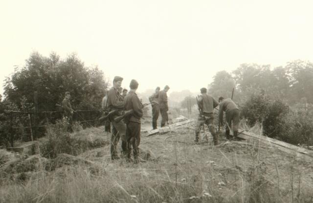 1968 wurde die Grenze modernisiert und ausgebaut. Grenzsoldaten der Volksarmee mit Gewehr im Anschlag bewachen die Arbeiter.
