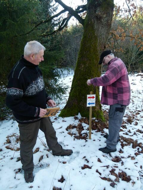 Vorsitzender Horst Erdel (links) und Wanderwart Holger Bötel (rechts) bringen die neuen Wegmarkierungen an der Rhein-Weser-Wasserscheide an. Links geht es das Hatzbachtal bergab, rechts bergauf Richtung "Nadelöhr".