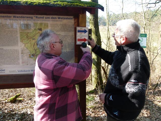 An der Hinweistafel am Startpunkt des Wanderweges bringen Wanderwart Holger Bötel (links) und Vorsitzender Horst Erdel (rechts) die ersten von vielen neuen Wegmarkierungen an.