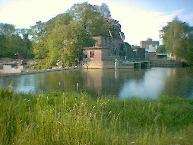 Schulenburg: Vorn das Ufer, an dem links neben dem Wehr sich die sehr schwierige Umtragestelle befindet. Links neben dem Kraftwerk die Baustelle des "Nur-Fischpasses". Rechts vom Kraftwerk die Einfahrt in den Umgehungsarm, der einen Borsten-Kombi-Kanu-Fischpass bekommen könnte.