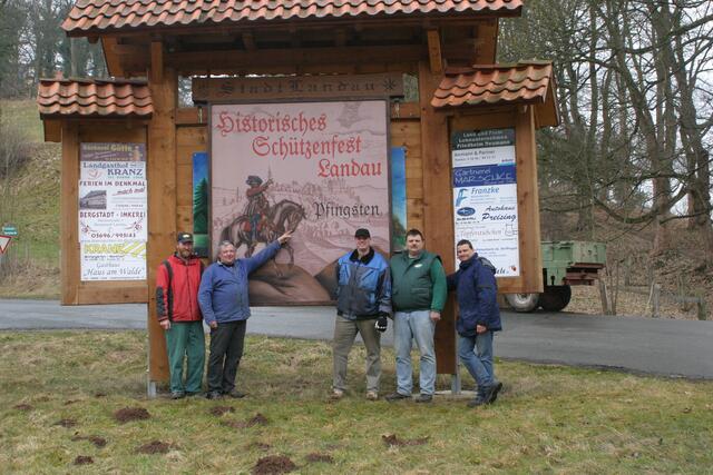 Nicht zu übersehen: Am Ortseingang hängt das Schild, das auf das große Fest zu Pfingsten hinweist. Hier Mitglieder der Gilde nach dem Aufhängen.