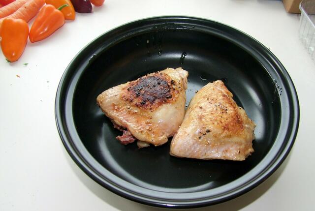 Vorgebratene Hähnchenteile in die Tajine setzen