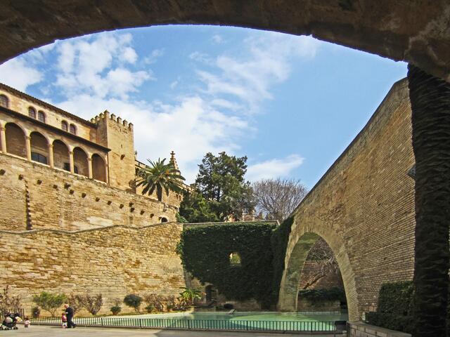 27.03.2012 Palma de Mallorca - Spanien. 
Stadt Palma.                                                                                
Palma de Mallorca. 
Königspalast Palau de l'Almudaina, 13. Jhdt.
Heute dient der Königspalast Palau de l'Almudaina dem spanischen Königspaar als Amtssitz, wenn sie Mallorca besuchen. (links).                                            Jardins de s'Hort del Rei - Königsgarten.
1. Arc de la Drassana Musulmana. (rechts)
