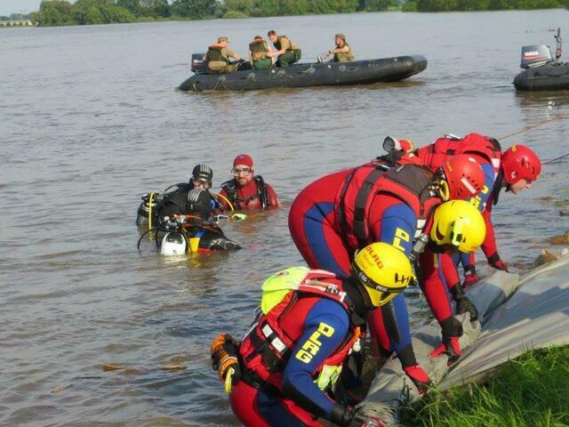 über Wasser wird die Folie ausgerollt, unter Wasser übernahmen die Taucher diese Arbeit