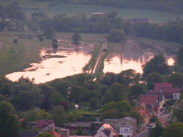 Die Sonne geht über der überschwemmten Wiese unter.