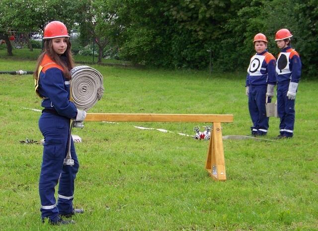 Vanessa Bartel wird gleich den C-Schlauch auswerfen - Gruppenführer und Melder beobachten aufmerksam