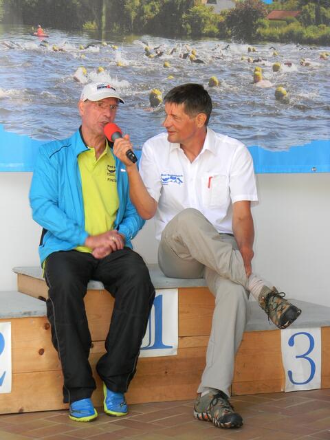 Organisator Edgar Strauß (re.) interviewt Raimund Schultz vom SC Lagenhagen. Er ist der einzige Teilnehmer, der an bisher allen (8 Stück) Seepark-Triathlons gestartet ist und seine jeweilige Altersklasse gewann, und immer auf der Mitteldistanz.