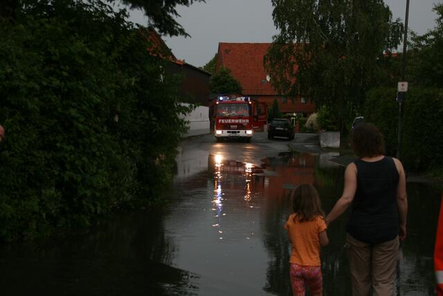 Feuerwehr und Anwohner beobachten das abfliesende Wasser