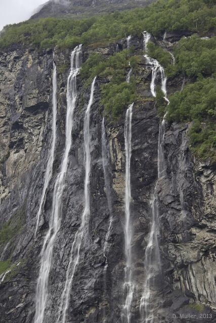 Wasser fällt von den Bergen, hier der Wasserfall "Die Sieben Schwestern" im Geiranger-Fjord, um den sich eine Sage rankt.