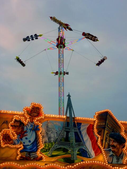 Bunte Lichter konkurrieren mit dem farbigen Abendhimmel.