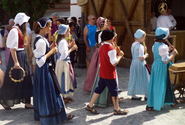 Kinder ziehen Flötenspielend durch die Straßen