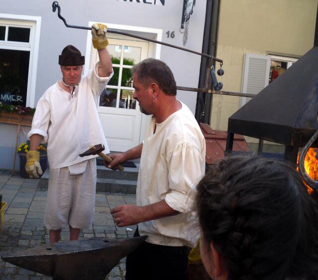 Der Blasbalg wird betätigt um das Feuer anzufachen