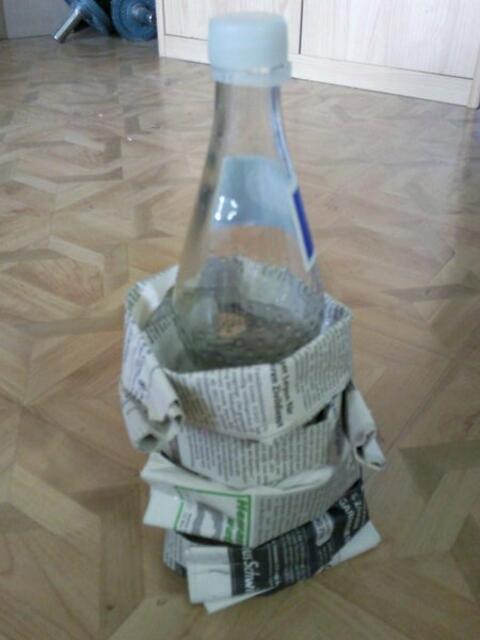 Man wickelt die Flasche,wie auf dem Bild zu sehen damit ein!(Am besten man tackert die Enden zusammen,damit es besser hält)