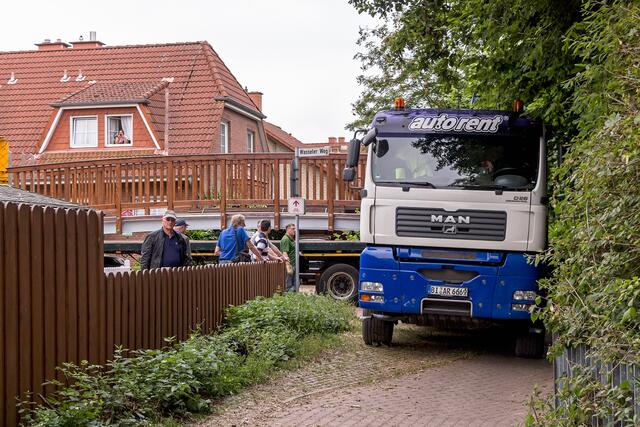 Die vorgefertigte Brücke wird am Müllinger Weg von einem Tieflader auf einen Kranwagen umgeladen