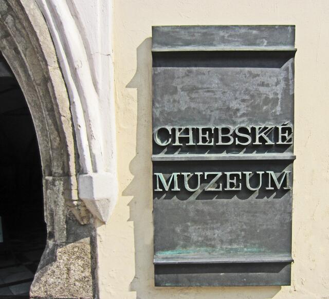 Das Bezirksmuseum Cheb, 
Krajské muzeum Cheb,
befindet sich in einem gotischen Bürgerhaus, 
Pachelbel-Haus (15. Jhdt.),
auf dem Marktplatz von Cheb.
Hier wurde der Feldherr Wallenstein, (1583 - 1634),
am 25. Februar 1634 ermordet. 
Die Ausstellung in seinem Sterbezimmer erinnert an Wallenstein und den Dreißigjährigen Krieg.