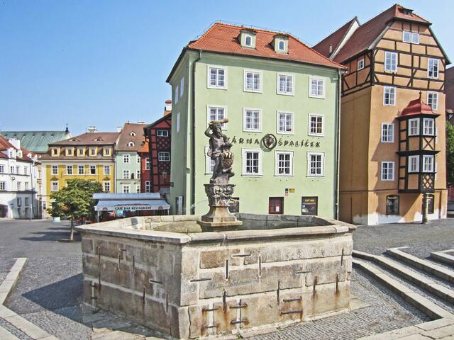 Marktplatz von Cheb (13. Jhdt.).
mit Stöckl und Herkules-Brunnen (1728). 
Herkules bewacht mit der vergoldeten Keule 
das Stadtwappen.