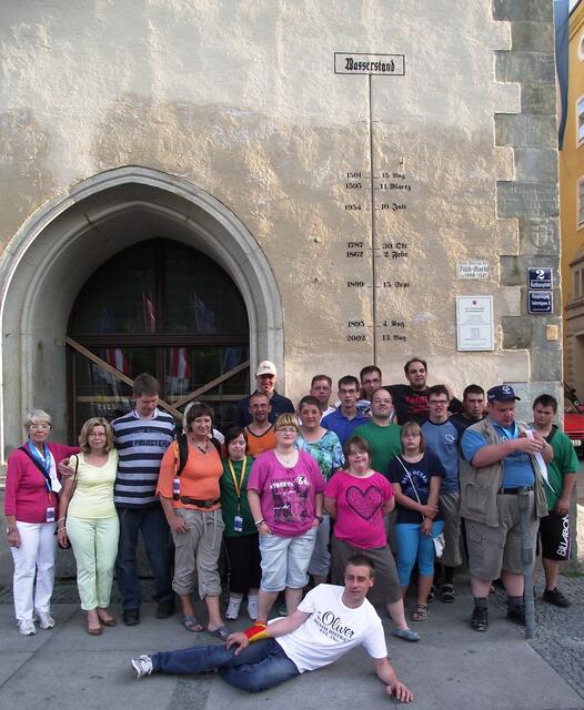 Die Gruppe am Rathhausplatz, Special Olympics 2013 in Passau. An der Hausmauer sind die Pegelstände des Hochwassers angezeichnet. 2013 ist ganz oben, kaum erkennbar.