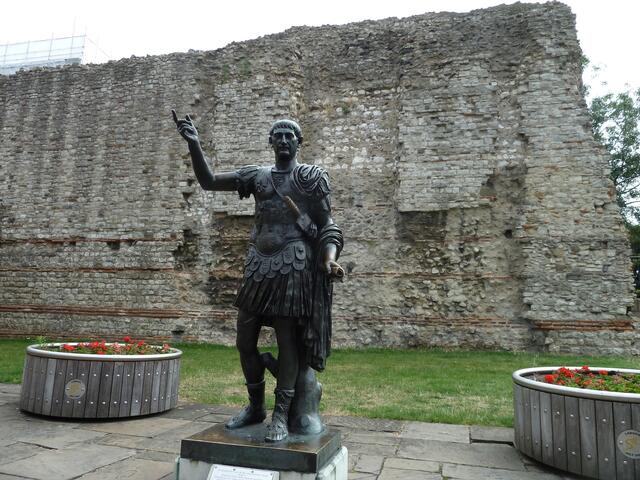 Vor einem Stück alter Mauer steht die Statue ,die den römischen Kaiser Trajan darstellen soll.