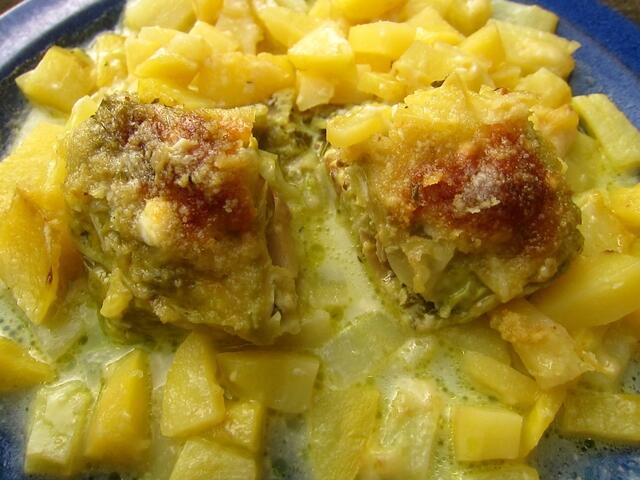 Ein Wirsing-Röllchen - durchgeschnitten - mit Kartoffeln