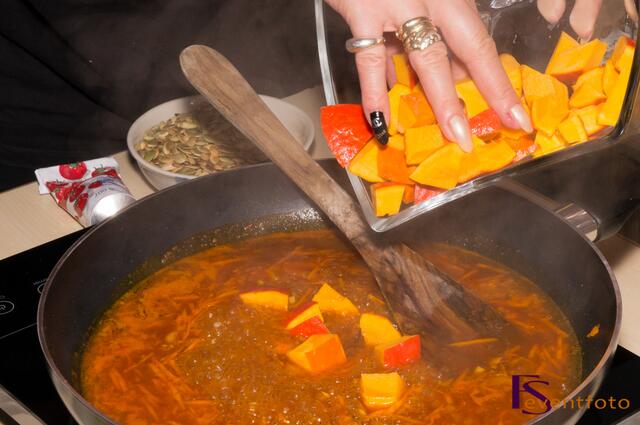 Kürbis-Karotten-Ingwer-Suppe - die Kürbiswürfel zugeben und weich köcheln