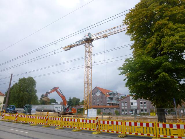 Sand wird abtransportiert. Der Baukran ist aufgestellt.