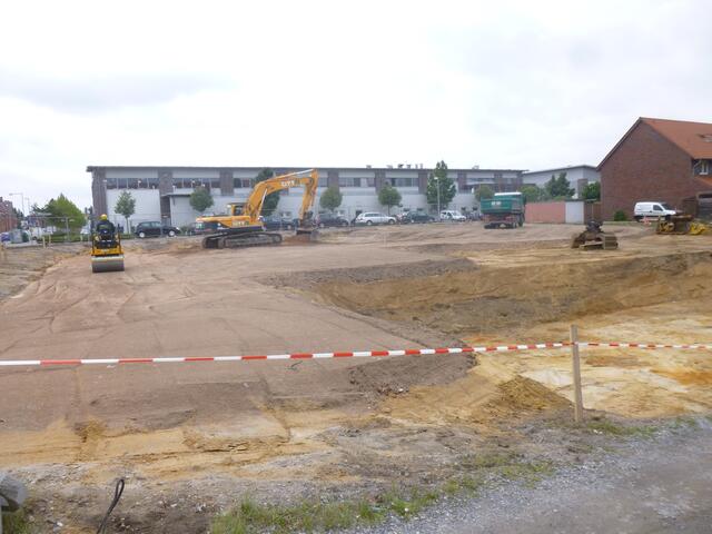 Planierungsarbeiten Adolf-Emmelmann-Straße/ Ecke Gebrüder-Hartmann-Straße. Im Hintergrund ist die Rückfront des Einkaufsparks Klein-Buchholz zu sehen.