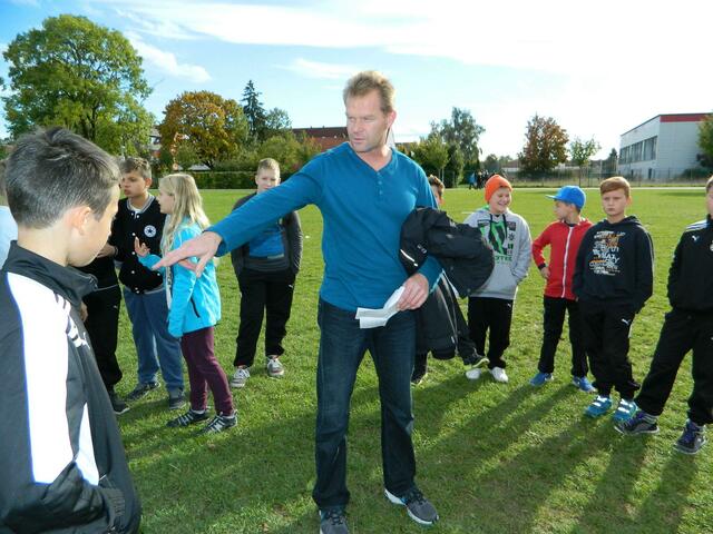 Trainer Knopf bespricht mit den Kindern ihre Position