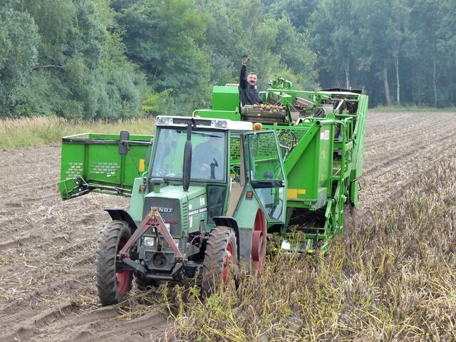 Kartoffelernte. Ein Gruß für die Jagdgesellschaft und Jagdreiter.