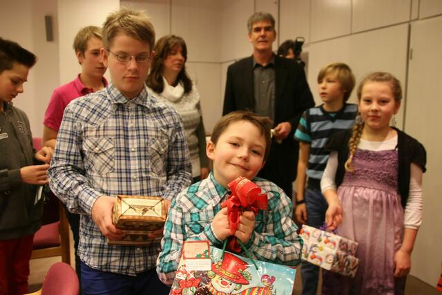 Die Kinder freuen sich, die Geschenke in den Händen halten zu können.