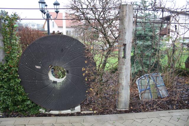 Mühlstein und Mühlenfenster als Teil der Zaunanlage