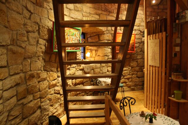 Treppenaufgang zur 2. Etage, rechts der "Elevator, dieser Fahrstuhl verbindet alle Etagen der Mühle, früher zum Transport des Mahlguts, heute für die Versorgung der Besucher mit Kaffee und Kuchen
