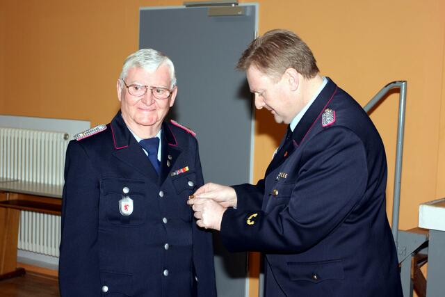 Karl Busch wird von Brandabschnittsleiter Eric Pahlke das Abzeichen des Landesfeuerwehrverbands Niedersachsen für langjährige Mitgliedschaft (50 Jahre) verliehen | Foto: Tino Kollmannsperger