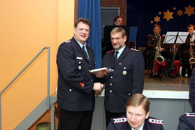 Ortsbrandmeister Thorsten Weinrich überreicht dem ausscheidenden Jugendfeuerwehrwart Bernd Uhlenwinkel ein Präsent für seine geleistete Jugendarbeit | Foto: Tino Kollmannsperger