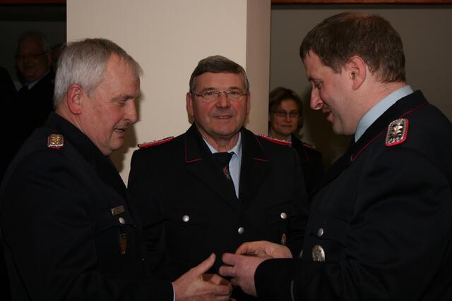 v.l.n.r. Horst Dobslaw und Gerd Wilhelm werden von stv. Ortsbrandmeister Sven-Heinrich Mensing nach Erreichen der Altersgrenze in den „Feuerwehr-Ruhestand“ versetzt und erhalten ein Abschiedsgeschenk.