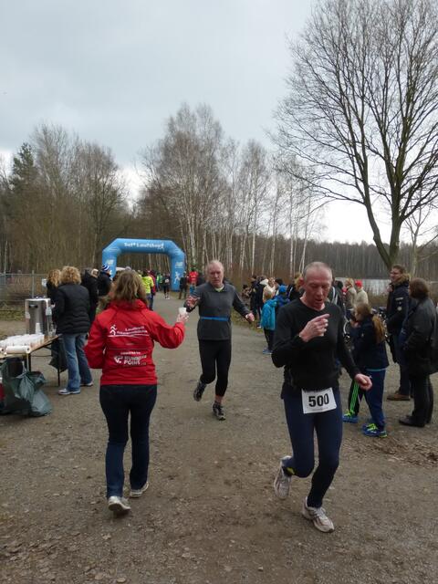 Die Läufer nehmen dankend die Getränke beim Rundendurchlauf an.