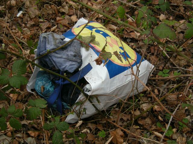 Zwischen den Buschen am Stadtparkteich eine Kleiderspende.