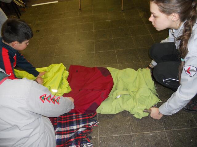 Vorbereitung der Trage mit Stöcken und Jacken