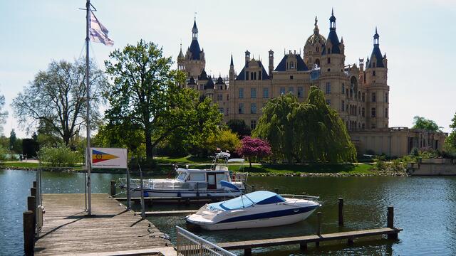 Bootssteg am Ufer des Schweriner Sees, im Hintergrund die Schlossinsel