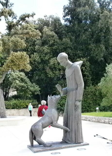 die Statue des Heiligen Franziskus mit einem Wolf ins Auge.
