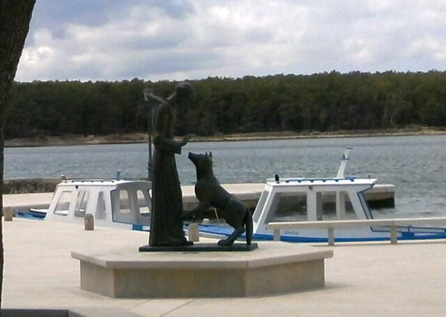 Bei der Ankunft fällt gleich an der Bootsanlegestelle die Statue des Heiligen Franziskus mit einem Wolf ins Auge.