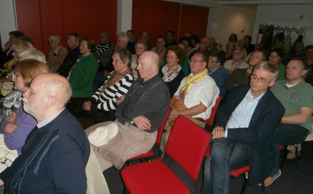 Über 60 Besucher der Veranstaltung hören aufmerksam zu.