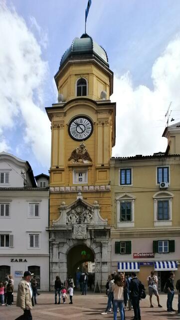 Ungefähr in der Mitte des Korzo befindet sich der Stadtturm aus 1750, das Wahrzeichen von Rijeka, mit dem habsburgischen Doppeladler und Abbildungen der zwei Kaiser Leopold I und Karl VI. Durch ihn kommen wir in die Altstadt. Der Turm ist eines der wenigen Gebäude der Stadt, die das große Erdbeben von 1750 überstanden hat.