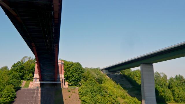 Für den Kraftfahrzeugverkehr entstand 1984 zusätzlich zur alten Levensauer Hochbrücke (links) die neue, eine vierspurige Brücke (rechts) über den Olof-Palme-Damm (B 76).